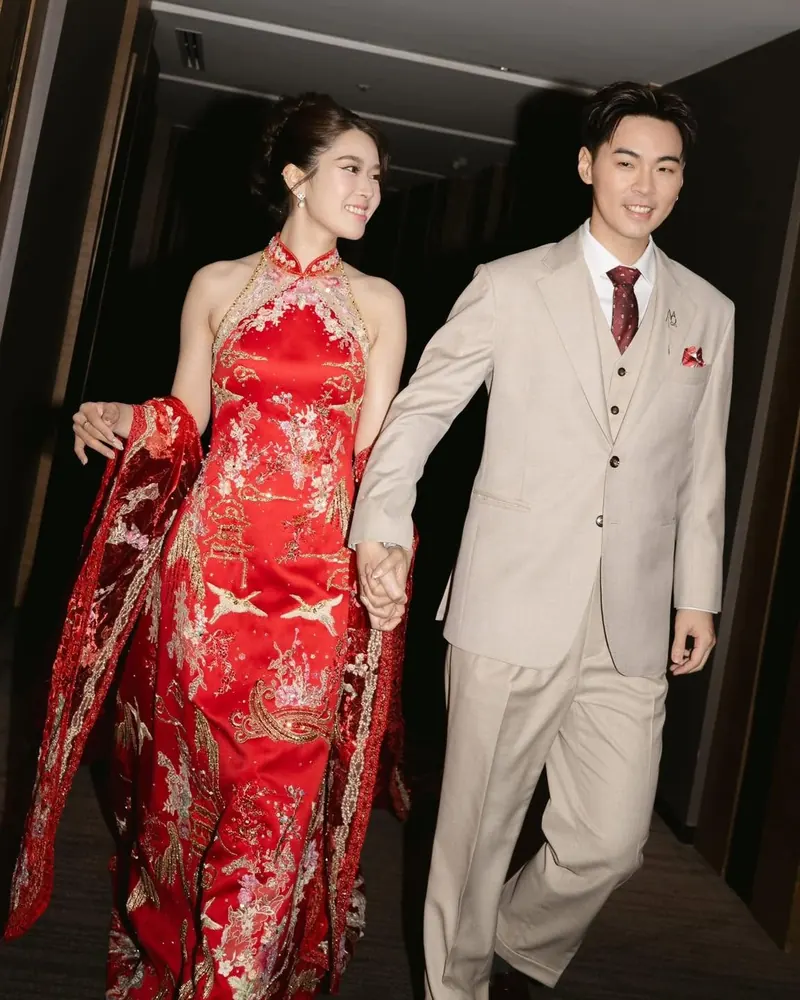 เจ้าสาวในกี่เพ้าสีแดงเดินกับเจ้าบ่าว